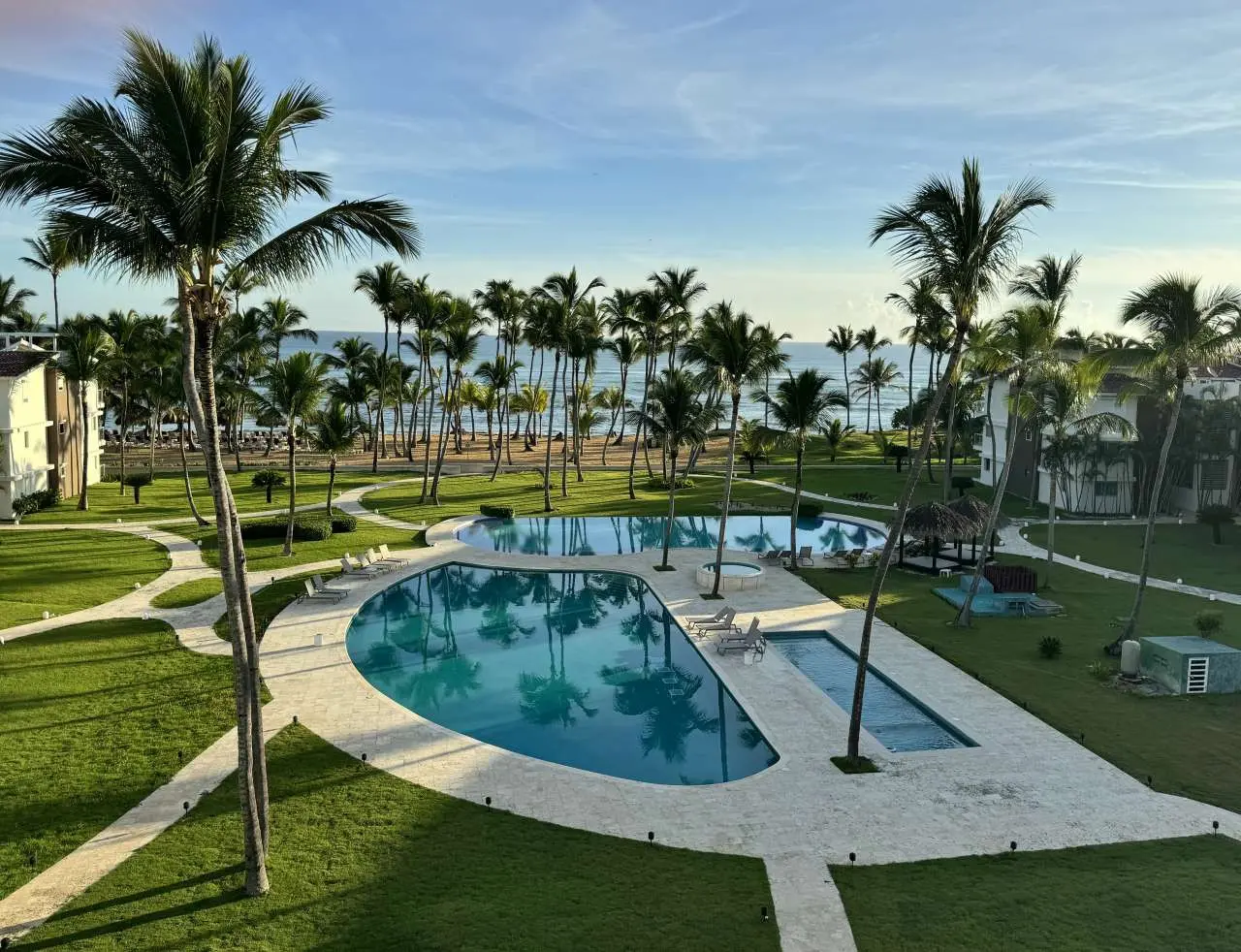 View from the Ocean View Apartments penthouse overlooking the pool, palm trees, green space and private beach